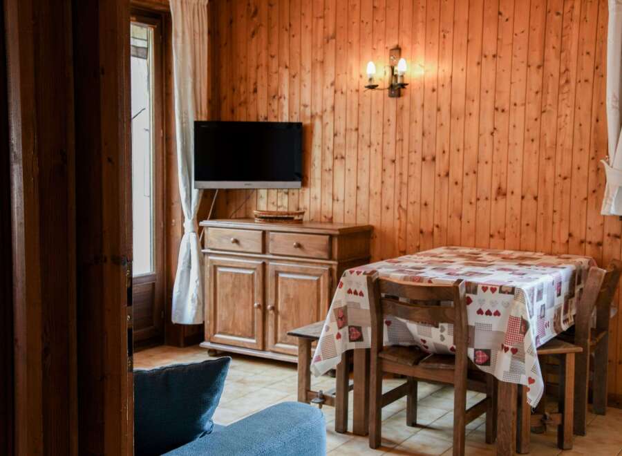 Cozy dining area with wooden paneling and a charming table setting.