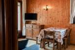Cozy dining area with wooden paneling and a charming table setting.