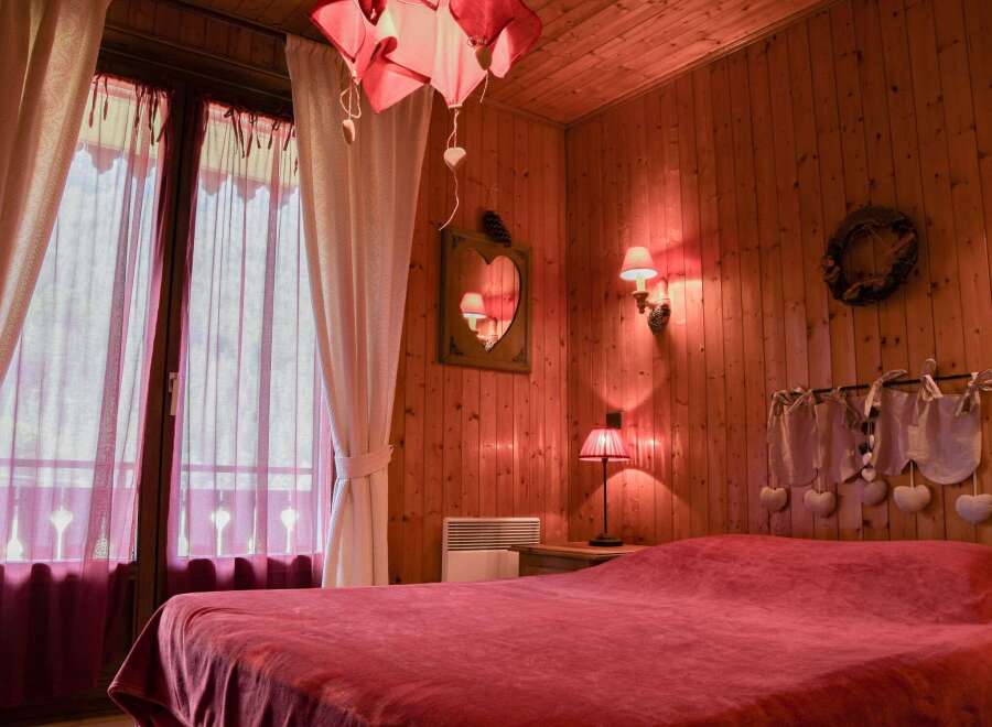 Cozy bedroom with wooden walls and a warm, inviting atmosphere.