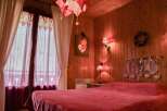 Cozy bedroom with wooden walls and a warm, inviting atmosphere.
