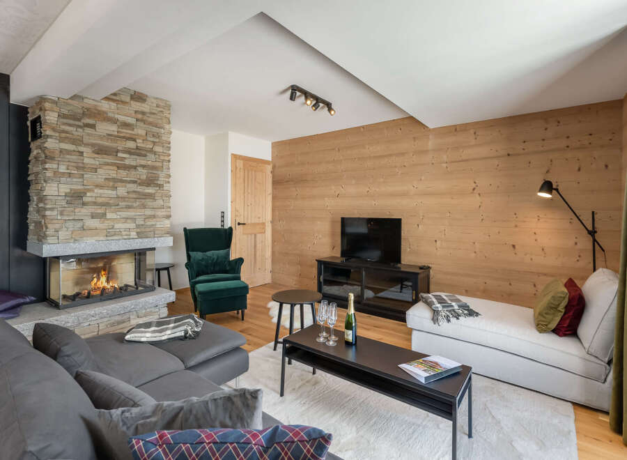 Experience luxury living in this stunning property featuring a cozy fireplace and a modern entertainment setup.