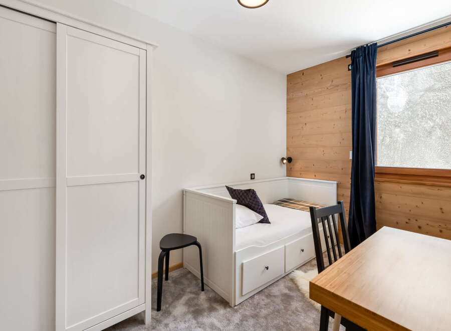 Discover a cozy bedroom retreat featuring a stylish white bed with storage drawers, perfect for maximizing space.