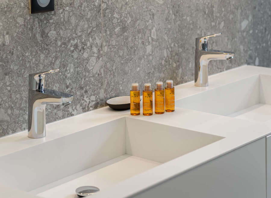 Indulge in luxury with this stunning bathroom featuring sleek, modern sinks and elegant chrome fixtures.