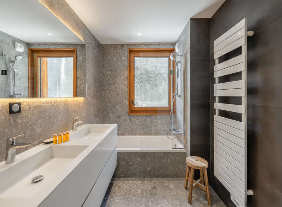Discover a modern bathroom design featuring a sleek double vanity and a luxurious bathtub.