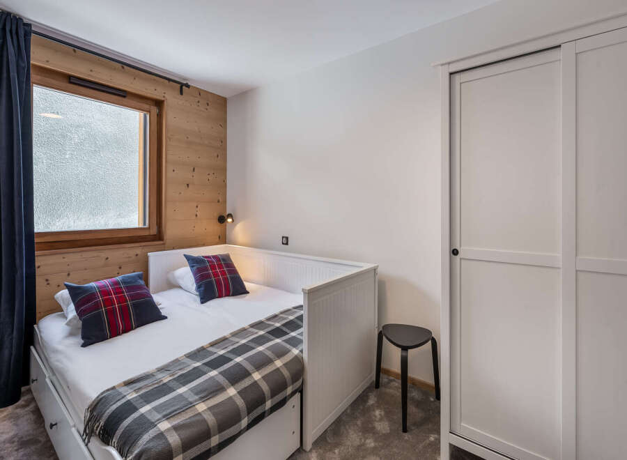Cozy bedroom with a comfortable bed and stylish plaid pillows.