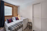 Cozy bedroom with a comfortable bed and stylish plaid pillows.