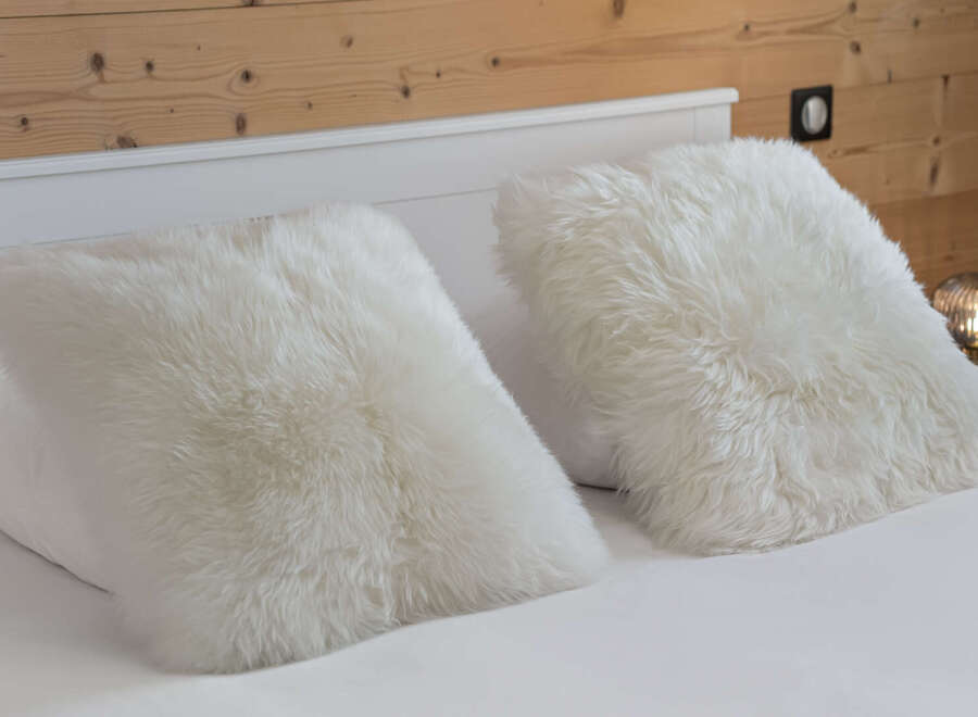 Cozy up in style with these luxurious white fur pillows.
