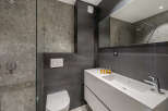Modern bathroom design featuring sleek gray tiles and a minimalist white vanity.