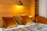 Cozy up in this inviting bedroom, featuring a plush bed adorned with luxurious pillows and a faux fur throw.