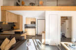 Discover a stylish and modern apartment with a well-equipped kitchen featuring sleek countertops and wooden cabinetry.