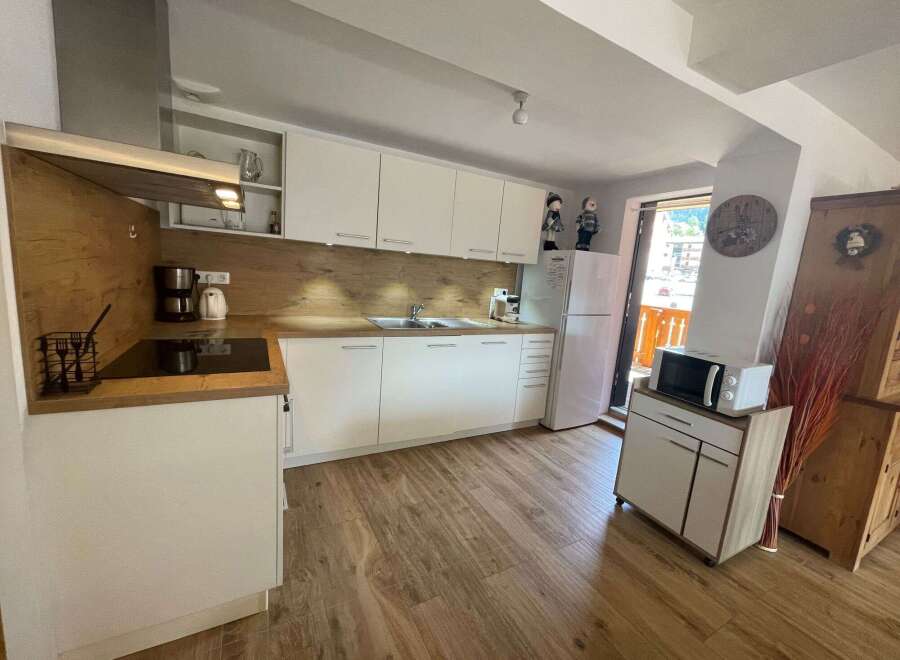 This charming kitchen boasts a modern design with sleek white cabinetry and warm wooden accents.