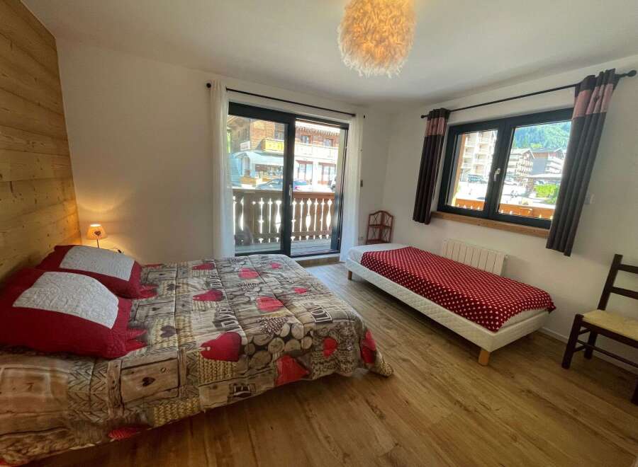 Cozy bedroom with a balcony offering stunning views.