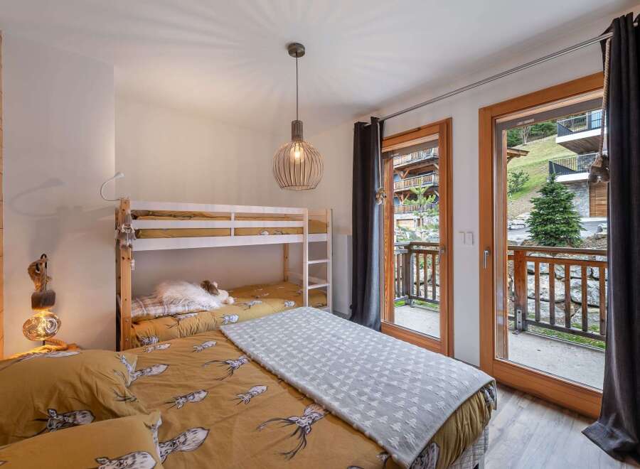 Cozy bedroom with a bunk bed and a comfortable double bed, perfect for families or groups.