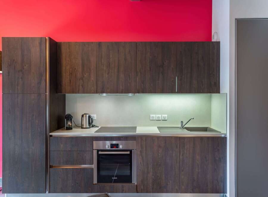 Modern kitchen design featuring dark wood cabinetry and a sleek stainless steel oven.
