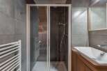 This modern bathroom features a sleek glass shower enclosure, perfect for a refreshing start to your day.