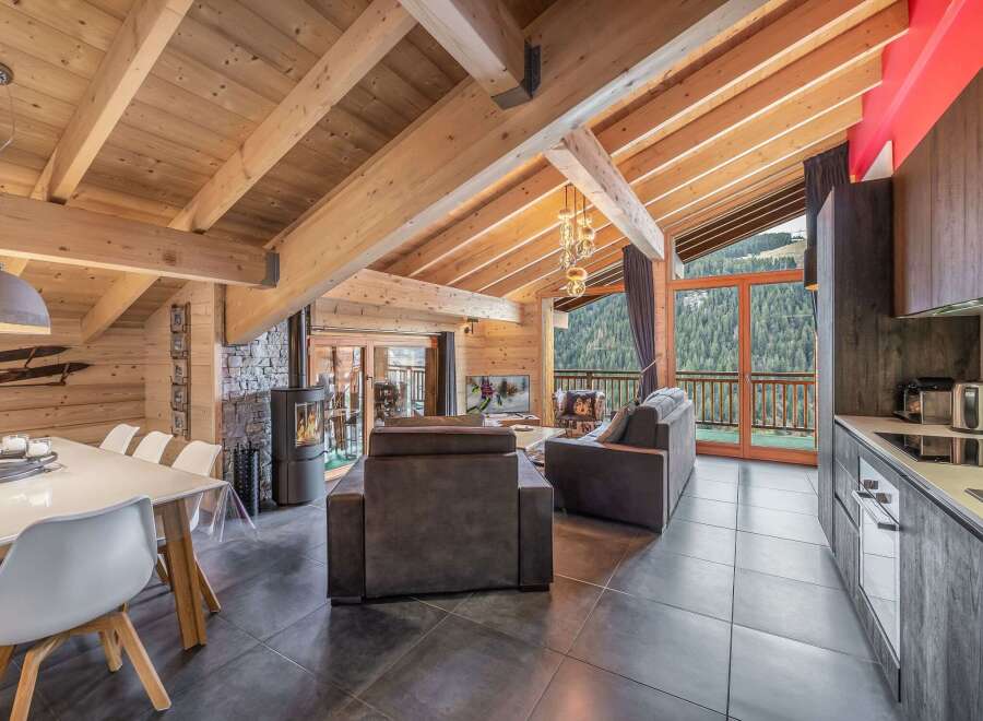 Experience luxury living in this stunning chalet, featuring a cozy fireplace and a modern kitchen.