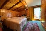 Cozy bedroom with wooden walls and ceiling, creating a warm and inviting atmosphere.