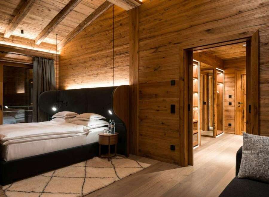 Experience luxury in this stunning bedroom featuring exquisite wooden paneling and a cozy ambiance.