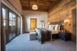 Experience luxury in this stunning bedroom featuring a cozy wooden ceiling and walls.