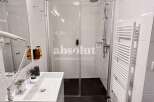 Discover a modern bathroom with a sleek glass shower and a convenient towel warmer.