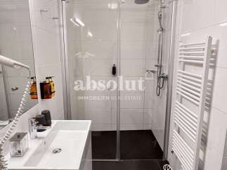 Discover a modern bathroom with a sleek glass shower and a convenient towel warmer.