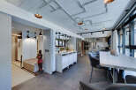 This modern kitchen boasts a unique industrial design with exposed pipes and stylish lighting fixtures.