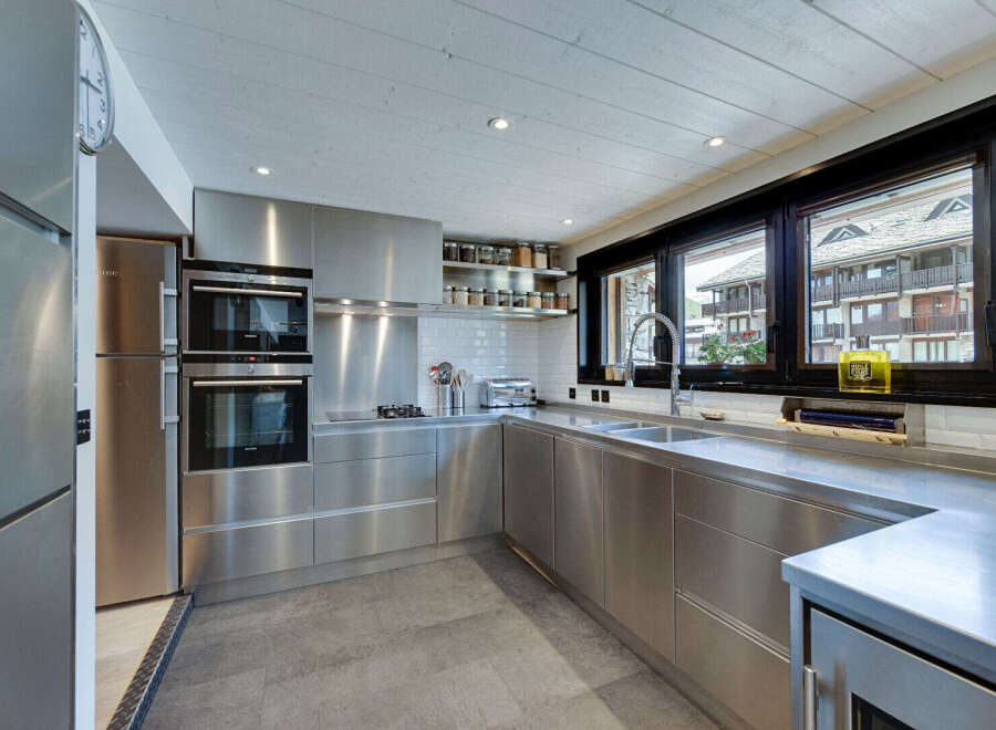 This modern kitchen boasts sleek stainless steel appliances and cabinetry, creating a contemporary and stylish space.