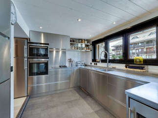 This modern kitchen boasts sleek stainless steel appliances and cabinetry, creating a contemporary and stylish space.