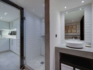 Experience modern luxury in this stunning bathroom featuring a spacious walk-in shower with white subway tiles and a sleek glass enclosure.