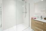 This modern bathroom features a sleek glass shower enclosure and a stylish vanity with ample storage.