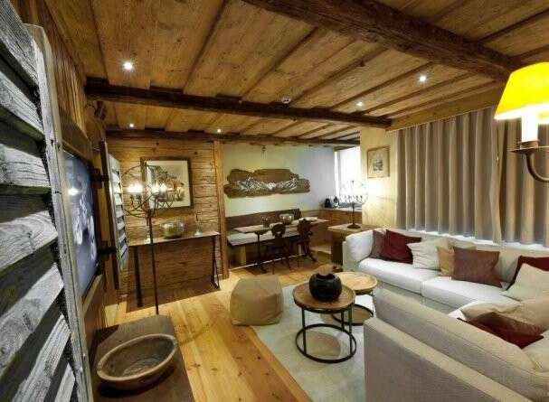 Experience rustic charm in this cozy living space, featuring a warm wooden ceiling and walls.