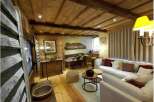 Experience rustic charm in this cozy living space, featuring a warm wooden ceiling and walls.
