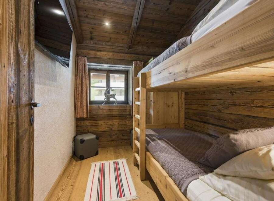 Cozy cabin bedroom featuring rustic wooden bunk beds, perfect for a family getaway.