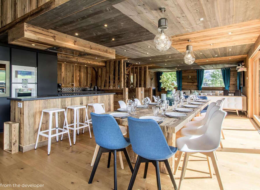 Experience luxury living in this stunning property, featuring a beautifully designed dining area with a rustic wooden aesthetic.