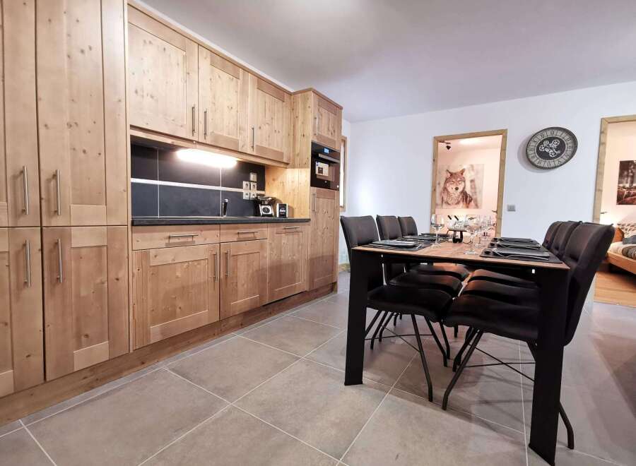 This stunning apartment boasts a modern kitchen with sleek wooden cabinetry and a spacious dining area, perfect for entertaining guests.