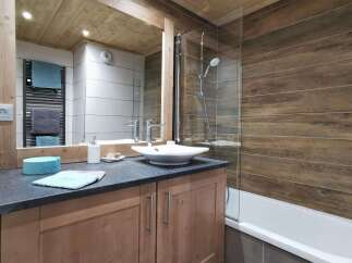 This stunning bathroom boasts a modern design with a sleek, white sink and a spacious bathtub.