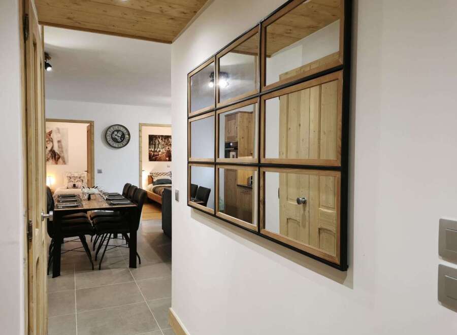 This stunning apartment boasts a spacious dining area with a sleek wooden table and modern chairs, perfect for enjoying meals with loved ones.