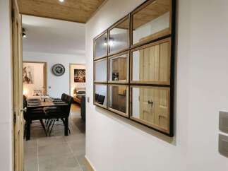 This stunning apartment boasts a spacious dining area with a sleek wooden table and modern chairs, perfect for enjoying meals with loved ones.
