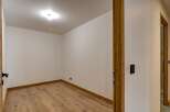 Step into this inviting space, featuring a warm wooden floor and pristine white walls.