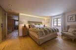 This cozy bedroom features a luxurious fur blanket and a comfortable armchair, perfect for relaxation.