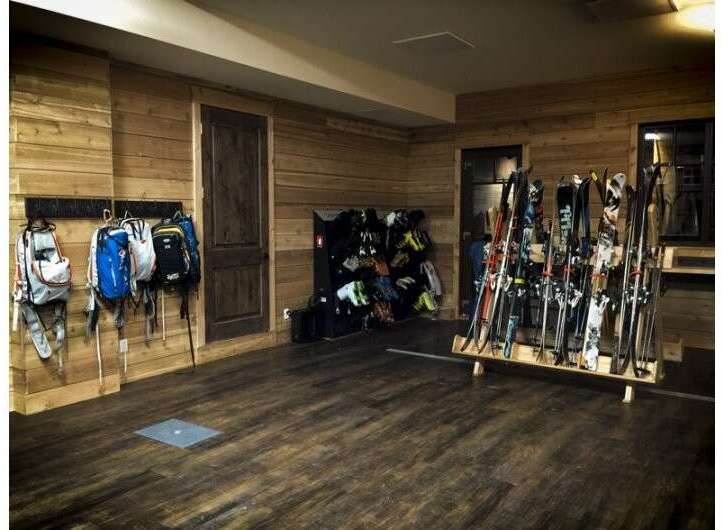 This cozy ski storage room features beautiful wood paneling and a warm, inviting atmosphere.