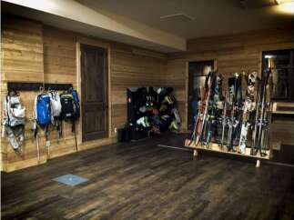This cozy ski storage room features beautiful wood paneling and a warm, inviting atmosphere.