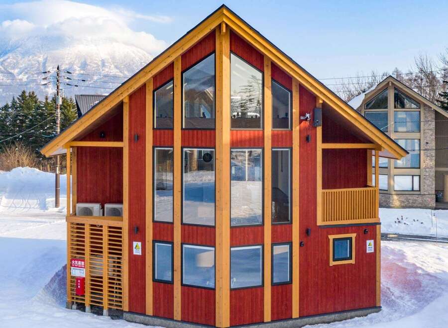 This stunning A-frame chalet boasts expansive windows offering breathtaking mountain views, perfect for a cozy ski retreat.