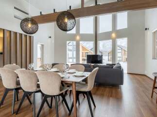 This stunning property boasts an open-plan living area with floor-to-ceiling windows offering breathtaking mountain views.