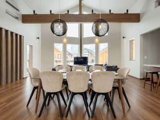 This stunning property boasts a spacious open-plan living area with floor-to-ceiling windows offering breathtaking mountain views.