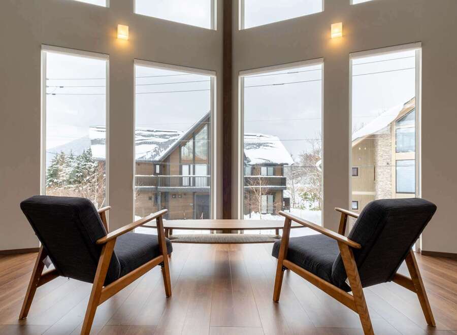This stunning property boasts expansive windows offering breathtaking views of a snow-covered landscape.