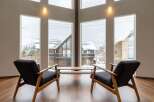 This stunning property boasts expansive windows offering breathtaking views of a snow-covered landscape.