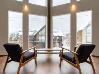 This stunning property boasts expansive windows offering breathtaking views of a snow-covered landscape.