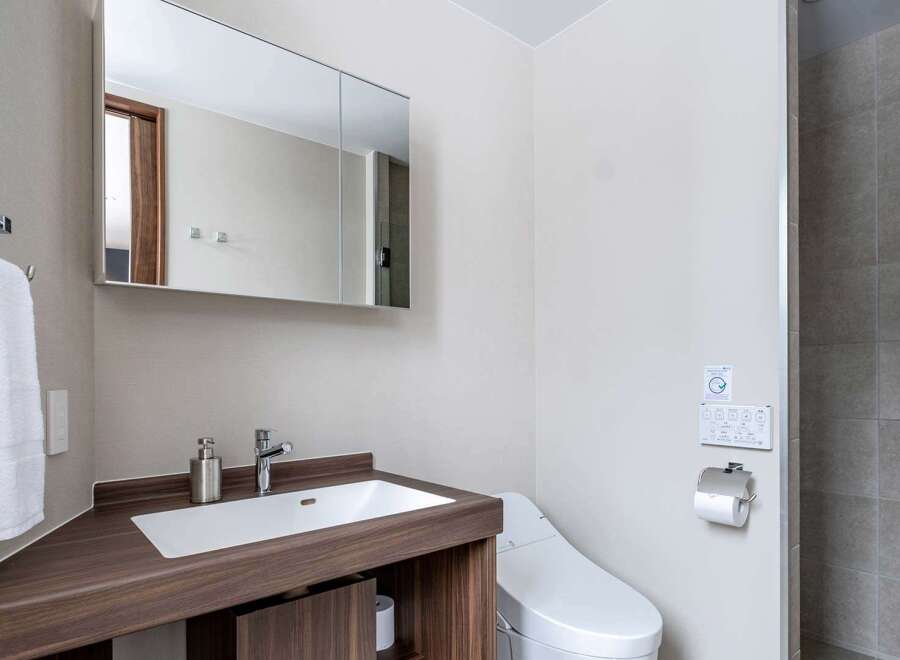 This modern bathroom boasts a sleek, dark wood vanity with a built-in sink and ample storage.
