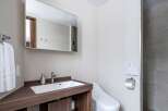 This modern bathroom boasts a sleek, dark wood vanity with a built-in sink and ample storage.